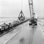 171035 Afbeelding van het vervoer van stenen per spoor ten behoeve van de aanleg van de Europoorthaven bij Rotterdam.